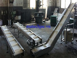 Băng tải xích tấm nhựa có vách trong nhà máy sản xuất đồ ăn